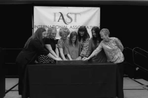 Black and white photograph of the IAST board with their hands pressed into one sandtray
